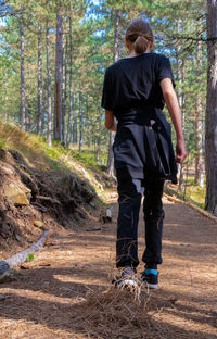 Rear view of men walking in forest