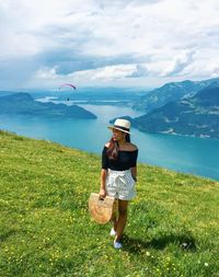 Woman standing on field against sky