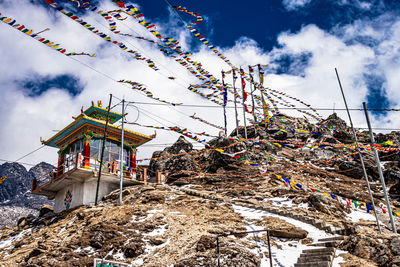 Small buddhist monastery at mountain top with many religious flags at morning