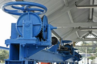 Close-up of machine part against blue sky