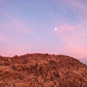 Rock formation on landscape against sky during sunset