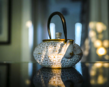 Close-up of illuminated lamp on table at home