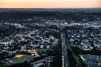 High angle view of illuminated city against sky at dusk