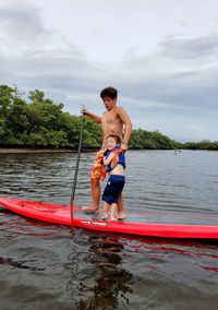 Younger brother almost knocks older brother off paddle board