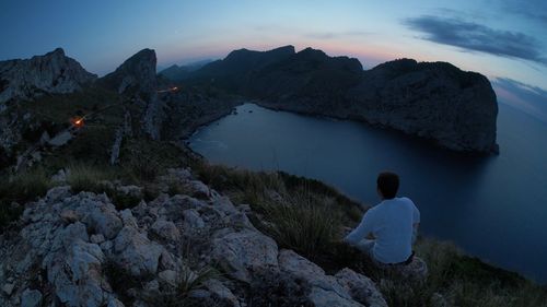 Rear view of man looking at mountain against sky