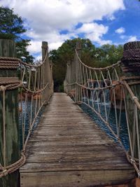 View of footbridge against cloudy sky