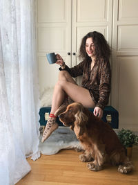 Woman with dog sitting on floor at home