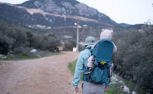 Man hiking in mountains,carrying baby in bacpack.travelling,trips,lifestyle.father,child,infant 