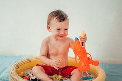 Shirtless baby boy having bath