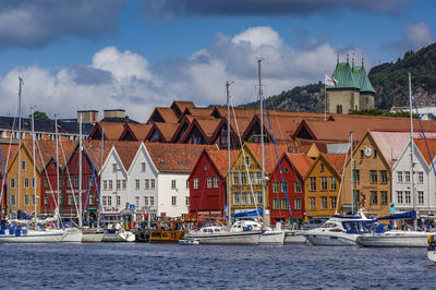 Houses by river against buildings in city