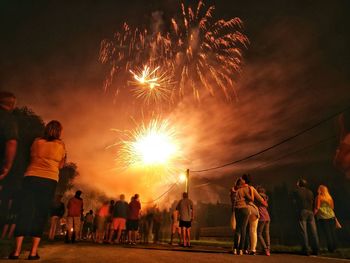 Low angle view of people watching firework display