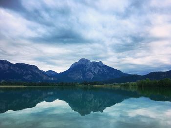 Scenic view of lake by mountains against sky