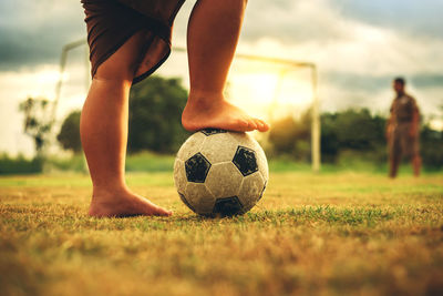 Low section of people playing soccer on field