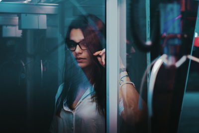 Close-up of young woman looking through window