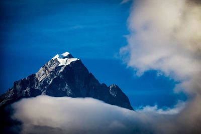 Scenic view of snowcapped mountains against blue sky