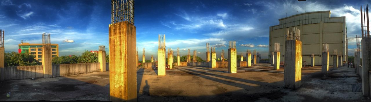 architecture, built structure, building exterior, sky, cloud - sky, city, cloud, cloudy, railing, outdoors, day, no people, sunlight, street light, the way forward, building, transportation, incidental people, industry, metal