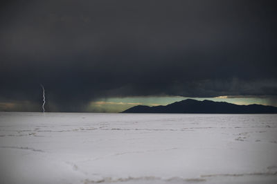 Idyllic shot of lightning on salt flat against cloudy sky