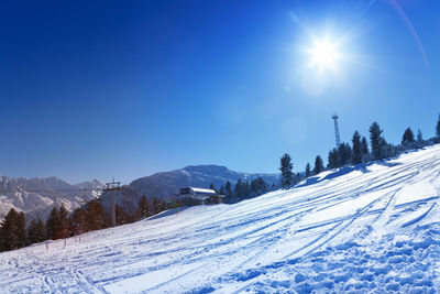 Scenic view of snow covered mountains against clear blue sky