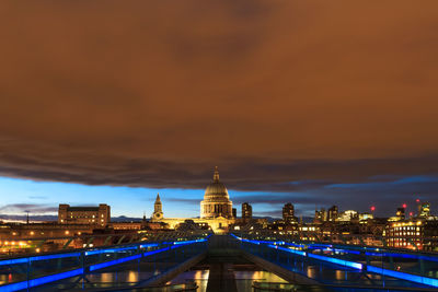 Illuminated buildings against sky at sunset