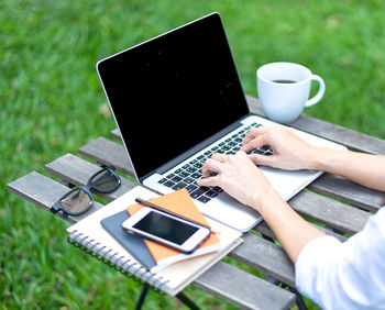 Midsection of man using laptop on table