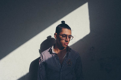 Young man standing against wall