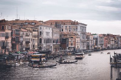 Boats in city against sky