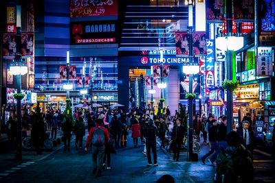 Crowd against building on street in city at night