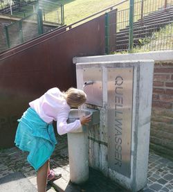 Rear view of woman standing against wall