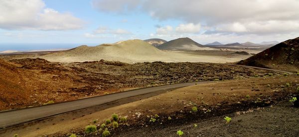 Road leading towards mountains against sky