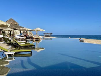 View of swimming pool by sea against clear sky