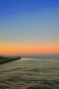 Scenic view of sea against clear sky at sunset