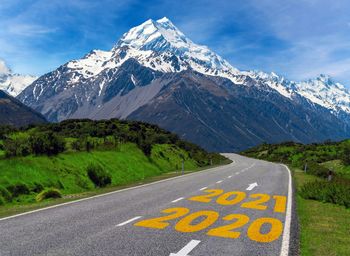 Road by mountains against sky