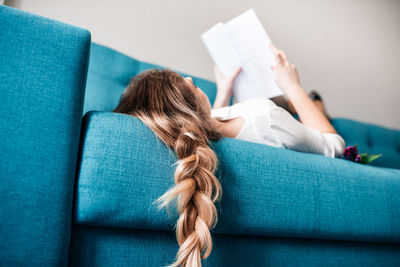 Midsection of woman sitting on sofa at home