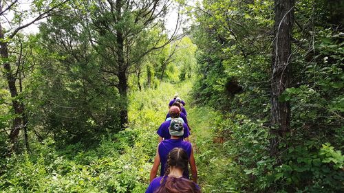 Full length of man riding woman in forest