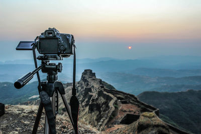 Close-up of camera against mountain range