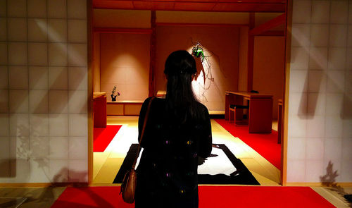 Rear view of woman standing in corridor