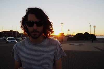 Woman standing on road at sunset