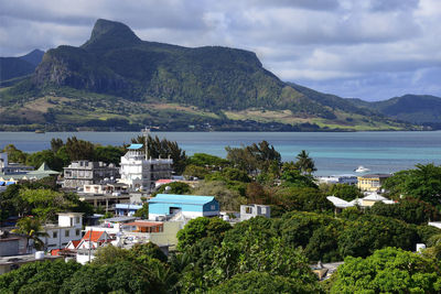 Scenic view of sea by townscape against sky