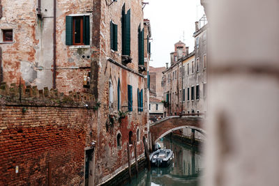 Arch bridge over canal amidst buildings