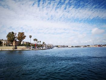 Scenic view of sea by buildings against sky