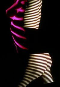 Close-up of illuminated light painting on wall in darkroom