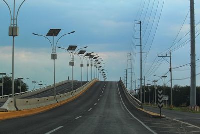 Street amidst road against sky in city