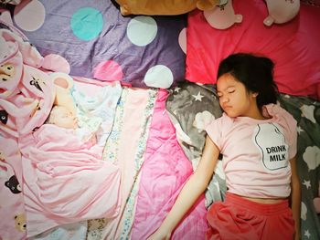 High angle view of cute girl sleeping on bed