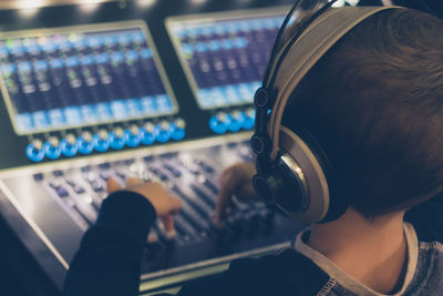 Cute boy mixing music in recording studio