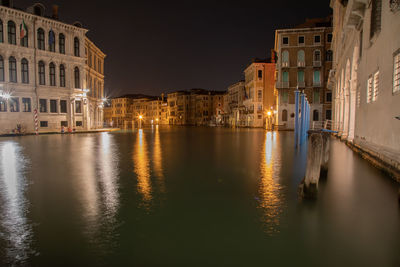 Canal passing through city buildings at night