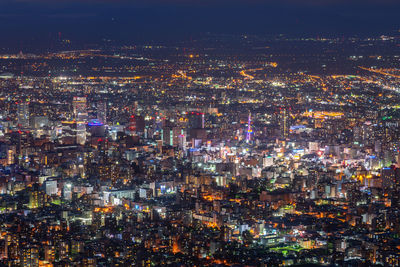 High angle view of illuminated cityscape against sky at night