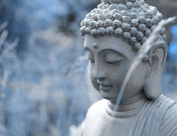 This little buddha is sitting in our garden. the photo is converted to blue 