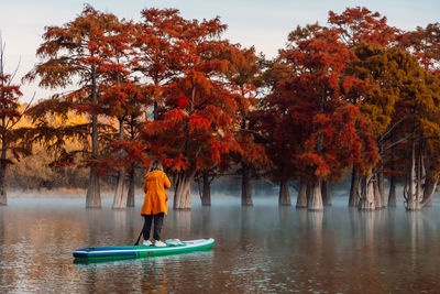 Rear view of woman standing in lake