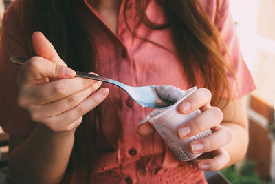 Close-up of woman eating yogurt