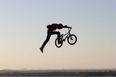 Man riding bicycle against clear sky